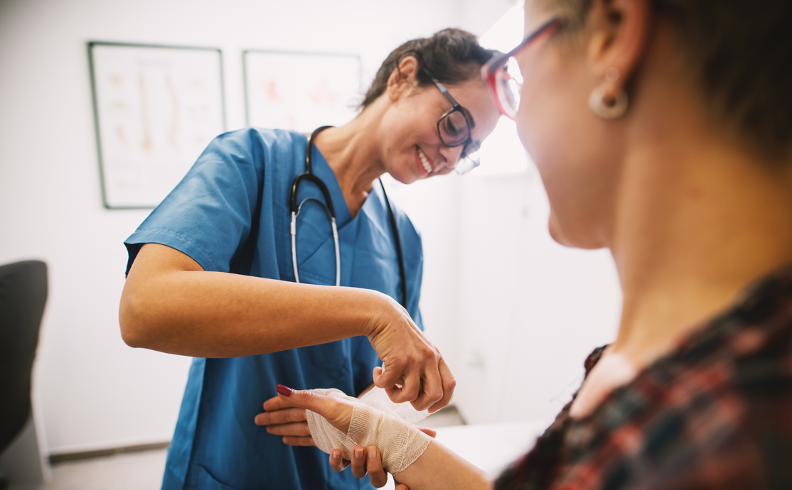 nurse applying bandage to a womans arm