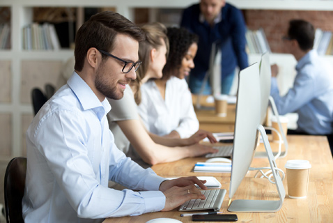 smiling male employee at computer